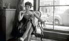 Actress Rita Moreno, sitting on a couch, February 1954.