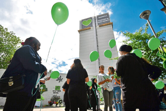 People release balloons at the Grenfell Memorial Community Mosaic at the base of the tower block in London on the third anniversary of the Grenfell Tower fire which claimed 72 lives on June 14 2017.