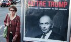 A woman walks past a poster of Eric Zemmour that reads ‘Our Trump’ in French in Biarritz, France
