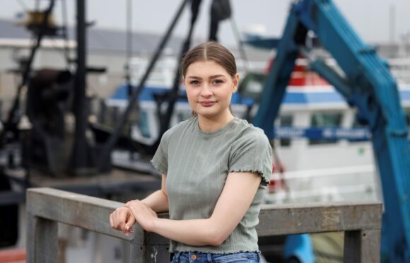 Abbie Jones, at Peterhead harbour, is among  students hailing the Open University.