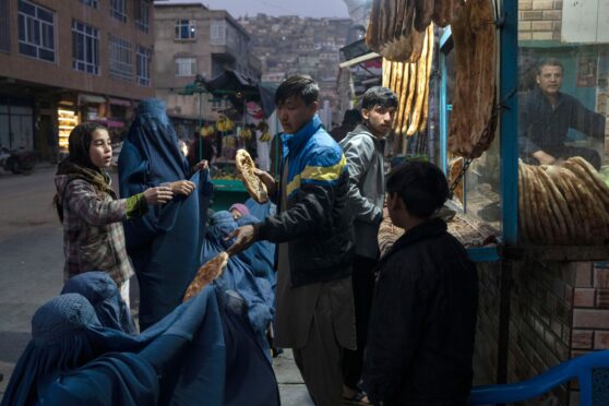 A man distributes bread outside a bakery in Kabul last month.