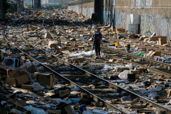 A camera man surveys the discarded boxes on the Union Pacific train track in downtown Los Angeles on Friday.