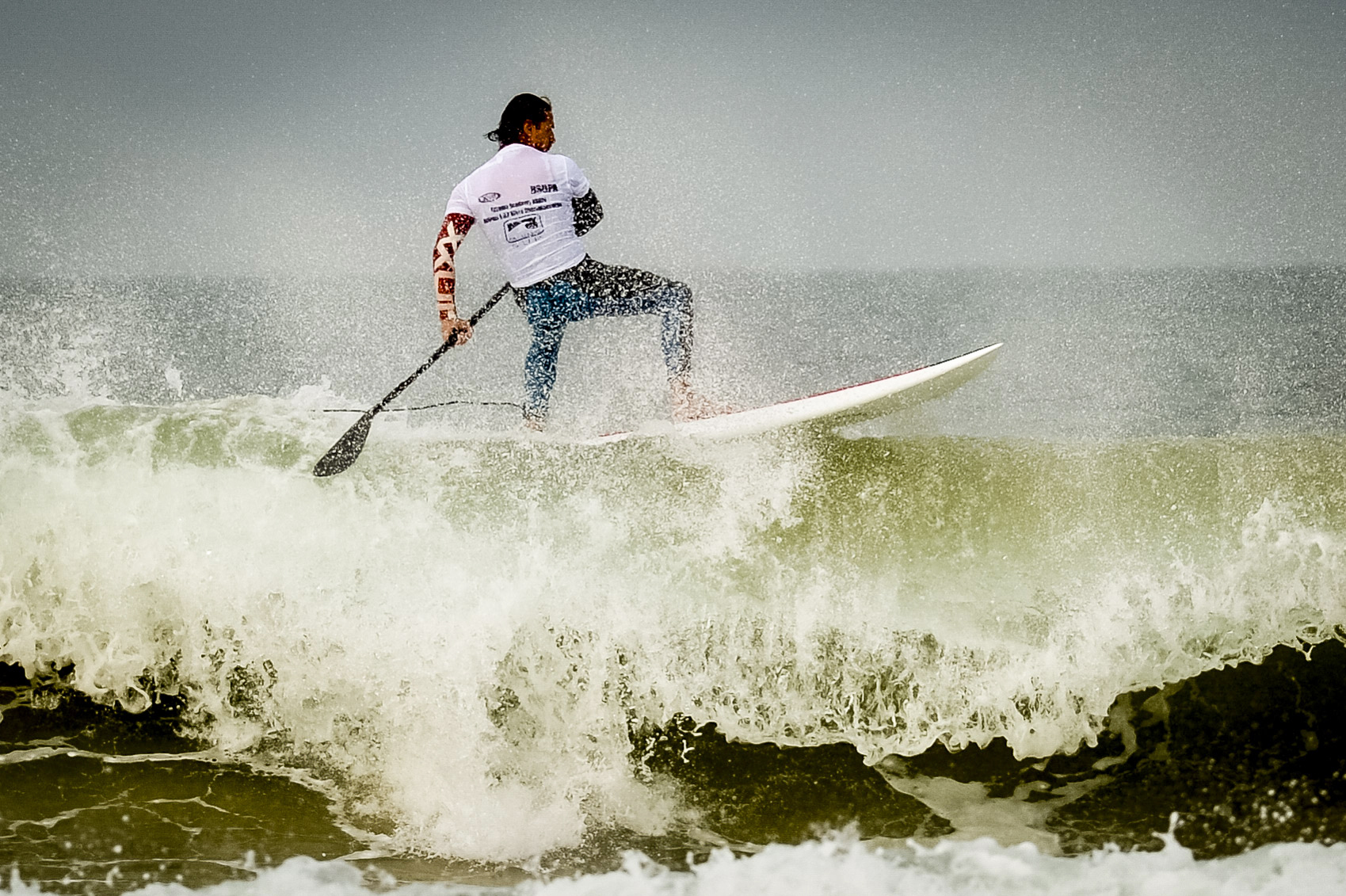 A stand-up paddleboarder floats on waves during British Sup Association championships at Watergate Bay, Cornwall in 2015
