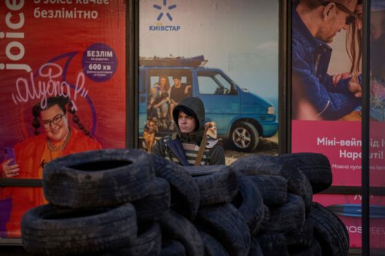 Armed, alone, vigilant and defiant, a civilian defence volunteer stands guard at a checkpoint in Kyiv, Ukraine, yesterday.