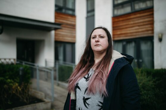 Ria Lewis outside her flat in Colonsay View, Edinburgh. Lewis is unable to sell as the flat is said to have unsafe cladding needing to be replaced