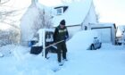 Bruce Harman clears a path through the snow in Tomatin, near Inverness