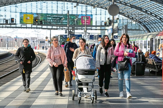 Refugees arrive in Berlin by rail.