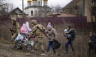 Ukrainian soldiers carry a baby stroller to help a family fleeing their home on the outskirts of Kyiv yesterday Picture