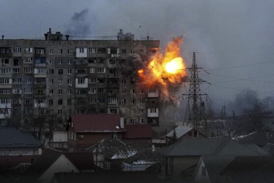 An explosion is seen in an apartment building after Russian's army tank fires in Mariupol, Ukraine.