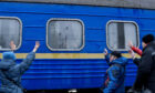 People wave as their relatives leave the city on an evacuation train at Kramatorsk railway station