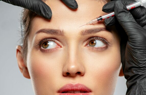 A model receives a Botox injection