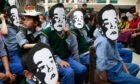 Exiled Tibetan children wear masks of Gedhun Choekyi Nyima, the Panchen Lama who, aged six, was taken by Chinese security forces