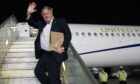 Prime Minister Boris Johnson waves as he boards his plane for the UK at Delhi airport at the end of his two day trip to India