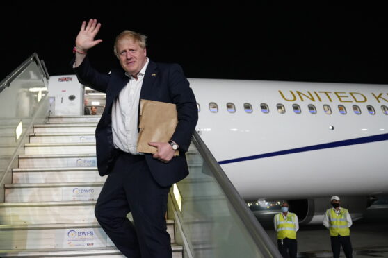 Prime Minister Boris Johnson waves as he boards his plane for the UK at Delhi airport at the end of his two day trip to India