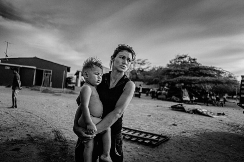 The Children of the Financial Collapse in Venezuela: A Venezuelan mother and her young child wait for relief aid in the border city between Venezuela and Colombia. New families arrive daily, with the rising cost of living in Venezuela, and lack of jobs.