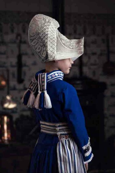The Identity of Holland: The traditional costume of Volendam is a masterpiece of Dutch culture. This elegant young lady in her beautiful cobalt blue dress the most beautiful deep blue I have ever seen is another example of why this culture must be cherished.