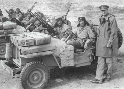 David Stirling, main, stands with SAS commandos after capturing Nazi jeeps in the African desert in 1943.