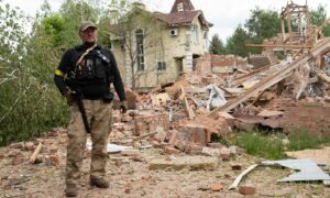 Ukrainian defence officer outside a ruined home in Sviatohirsk