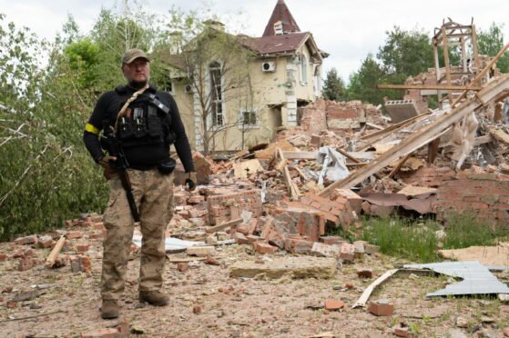 Ukrainian defence officer outside a ruined home in Sviatohirsk