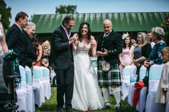 Lucy is walked down the aisle at Inchberry Hall by her father Robert, left, and Tommy’s dad Tony, right