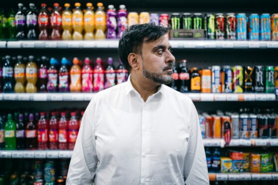 Mohammed Rajak in his shop in Bridgeton, Glasgow, where he was previously attacked with a machete