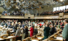 MSPs and chamber guests sing Auld Lang Syne at the new Scottish Parliament building at Holyrood to mark its official opening on October 9, 2004