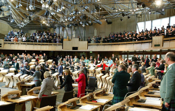 MSPs and chamber guests sing Auld Lang Syne at the new Scottish Parliament building at Holyrood to mark its official opening on October 9, 2004