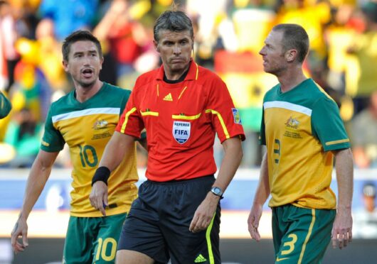 Craig Moore pleads with referee, Roberto Rosetti, not to send off Harry Kewell during a match against Ghana at the 2010 World Cup Finals, but it fell on deaf ears