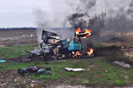 The remains of a tractor blown up by a Russian landmine burns in a field in Chernihiv, Ukraine