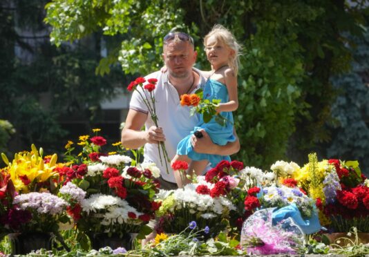 Mourners in Kremenchuk lay flowers for the victims of the cruise missile attack on a shopping centre which claimed 18 lives on Monday