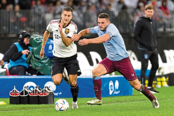 John McGinn, complete with captain’s armband, challenges Diego Dalot of Manchester United.