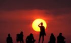 People turn out to watch the sunrise at Cullercoats Bay, North Tyneside.