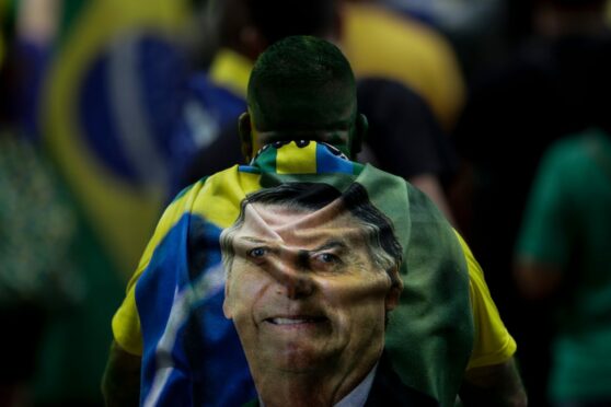 Supporter with a towel depicting the president of Brazil Jair Bolsonaro draped on his back attends a rally to launch Bolsonaro’s re-election bid in Rio de Janeiro
