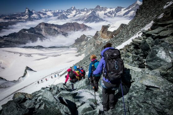 Sarah descending the summit of the Allalinhorn on a scree slope.