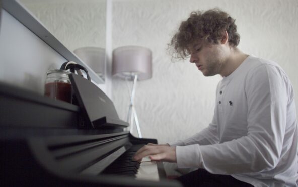 Robbie plays the piano at his home in Bishopbriggs