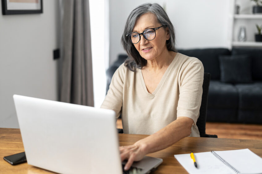 Older woman with a laptop - article about surveys for money for the Sunday Post