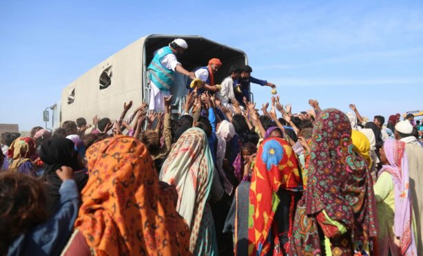 People affected by floods receive aid in Sehwan, Sindh province.