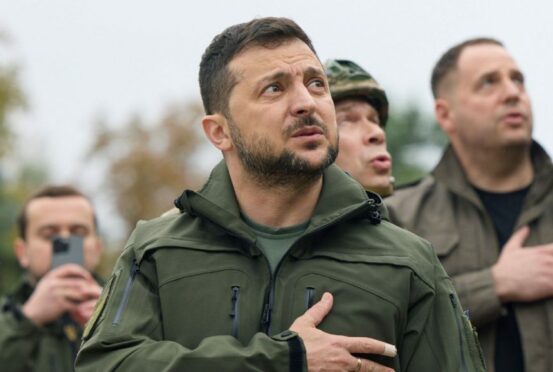 Hand on heart, president Volodymyr Zelensky watches the Ukrainian flag rise once more in the reclaimed city of Izyum.