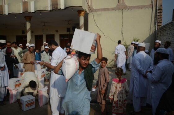 People affected by floods receive relief aid distributed by the Al Khidmat Foundation in Nowshera District, Garhi Momin Village, Khyber Pakhtunkhwa province.