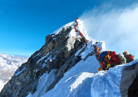 A queue of climbers wait in a 500-metre line as they approach the summit of Mount Everest in infamous photograph from 2019