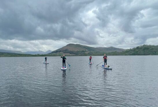 Rachel and friends show off their paddleboarding skills on Loch Tay