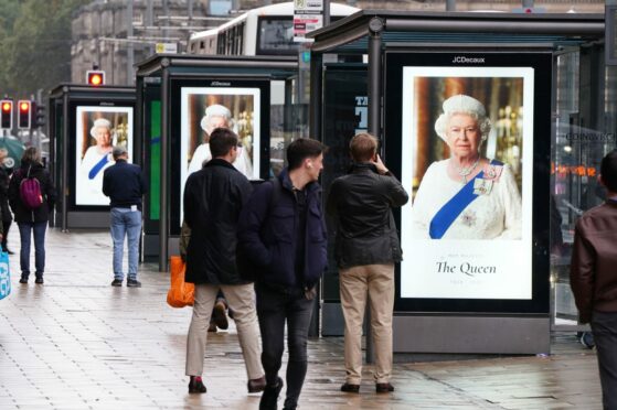 Tributes to Queen Elizabeth II on bus stops on Princes Street in Edinburgh on Friday