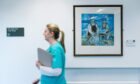 Clinical Nurse Manager at Quarriers Epilepsy Centre in Govan, Lauren McIntyre, walks past a painting that is part of the Art in Healthcare collection.