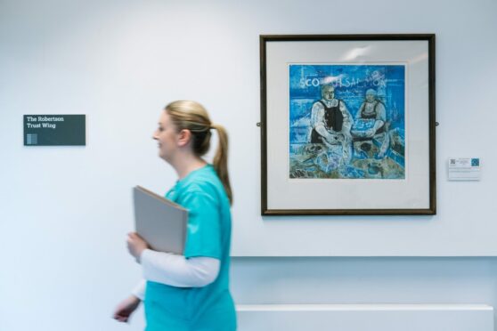 Clinical Nurse Manager at Quarriers Epilepsy Centre in Govan, Lauren McIntyre, walks past a painting that is part of the Art in Healthcare collection.