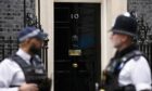 Two policemen stand guard near the front door to 10 Downing Street