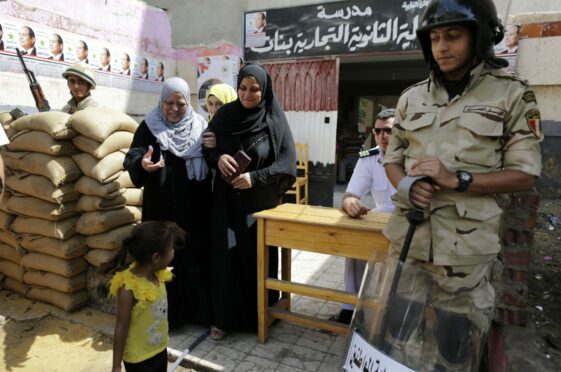 Soldiers stand guard as voters leave a polling station in Cairo during Egyptian presidential elections