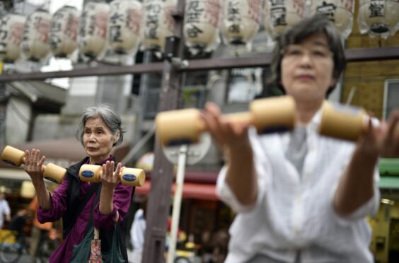 Women work out with dumbbells during an event marking Respect For The Aged Day in 2016 in Tokyo, Japan