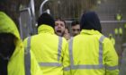 A migrant shouts for help to the press at Manston processing  facility in Kent.