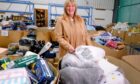 Pauline Buchan, strategic manager of The Cottage Family Centre charity, sifts through items at Amazon’s Lochgelly 
depot in Fife