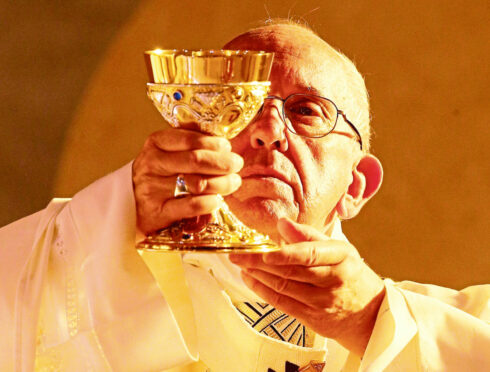 Pope Francis raises the Holy wine during a visit to the parish of San Pier Damiani in Rome.